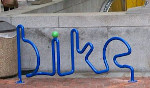 Bike rack that spells out the words bike here